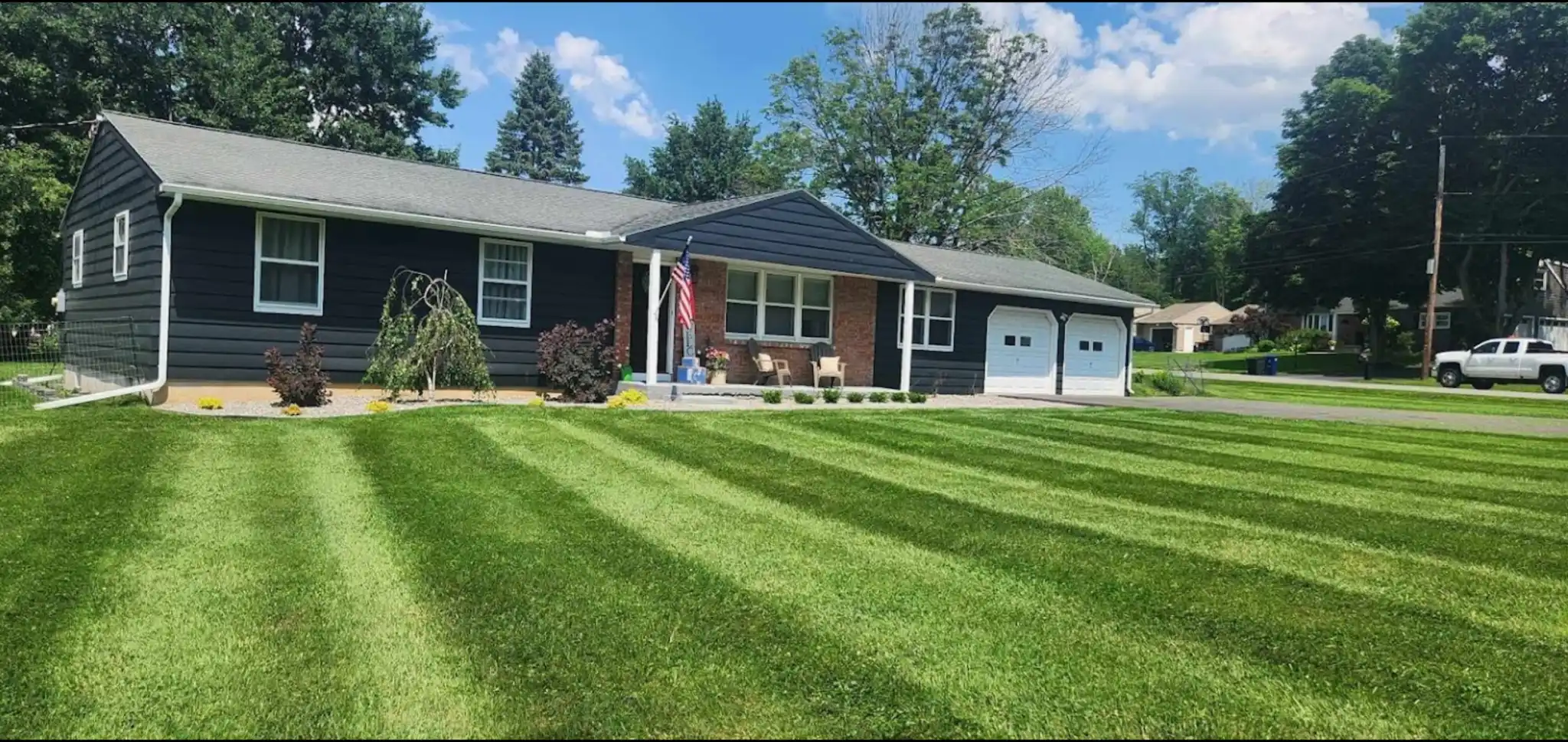 Professional lawn mowing with clean stripes on a large green lawn in Utica, NY