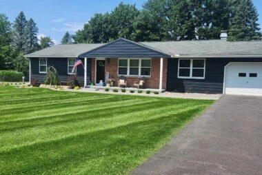 Freshly mowed lawn with clean edges in front of a home after professional lawn maintenance in New Hartford, NY
